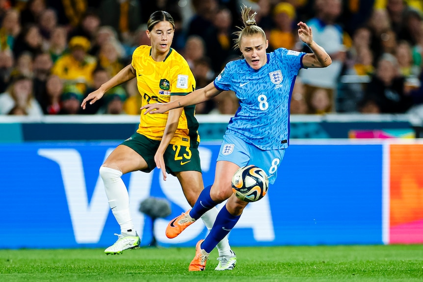 An England player and a Matildas opponent challenge for the ball during the Women's World Cup semifinal.