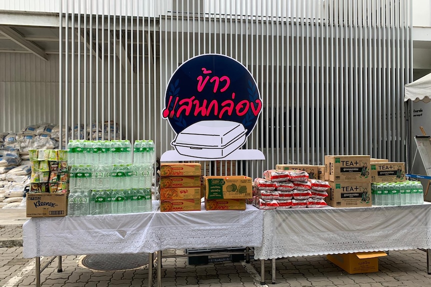 Stacks of packaged food and bottled water on a table 