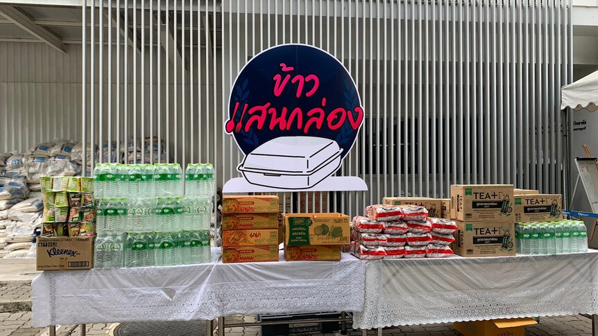 Stacks of packaged food and bottled water on a table 