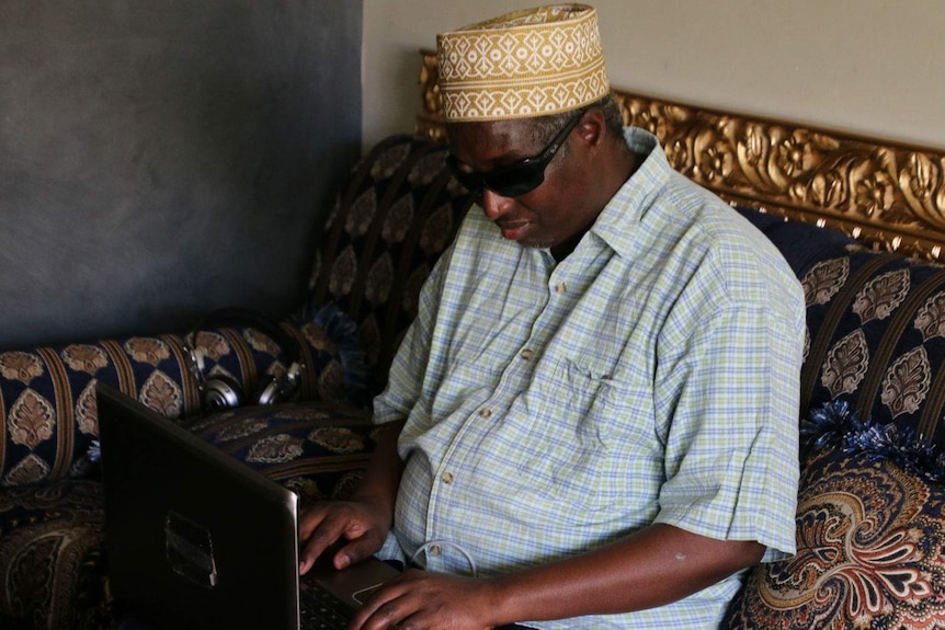 Siyat Abdi sitting in a room with his laptop on his lap.