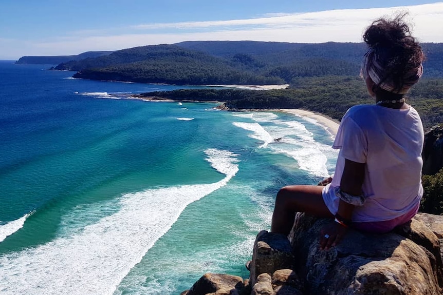 Person looks out across coastline.