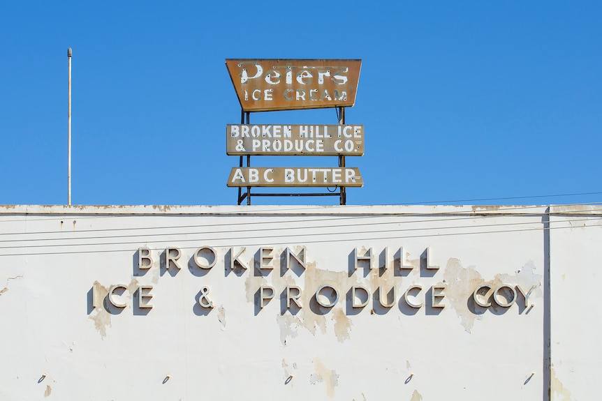Verblasste Werbeschilder für Eis und Butter in Broken Hill.