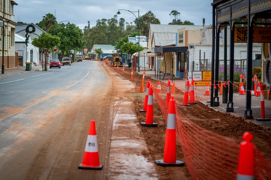 A country town main street with witch's hats in it and dirt