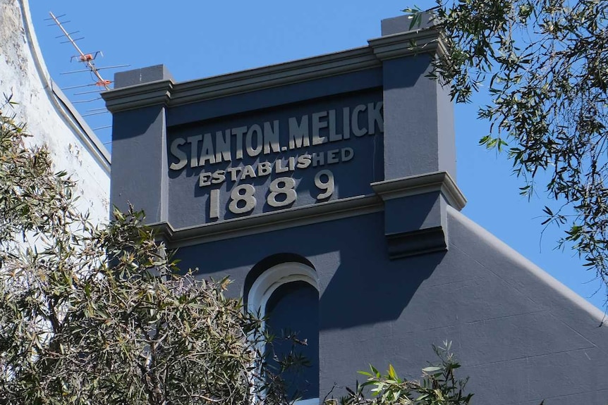 The top of an old terrace building, painted blue, with a sign saying Stanton Melick, 1889.