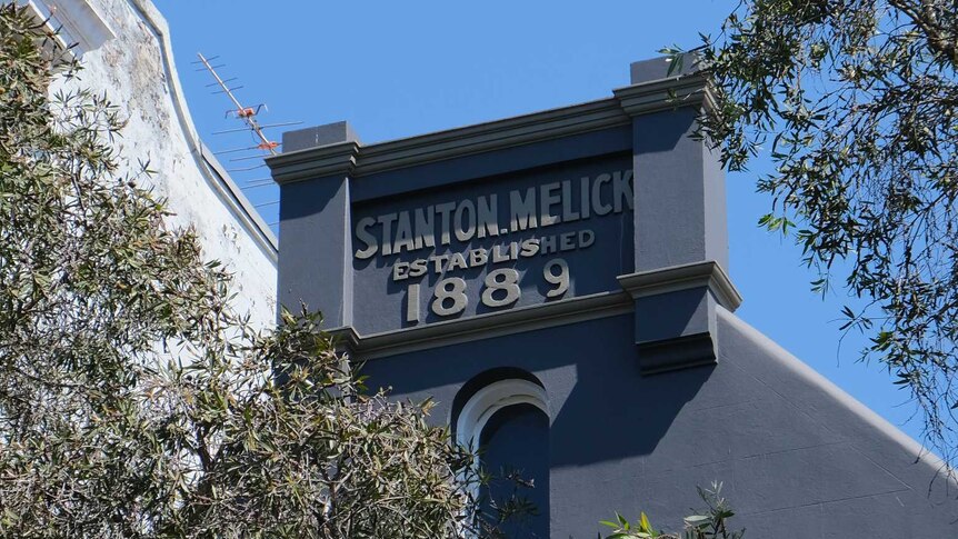 The top of an old terrace building, painted blue, with a sign saying Stanton Melick, 1889.
