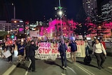 Hundreds of anti-Adani protesters march over Victoria Bridge towards the ABC at South Bank.