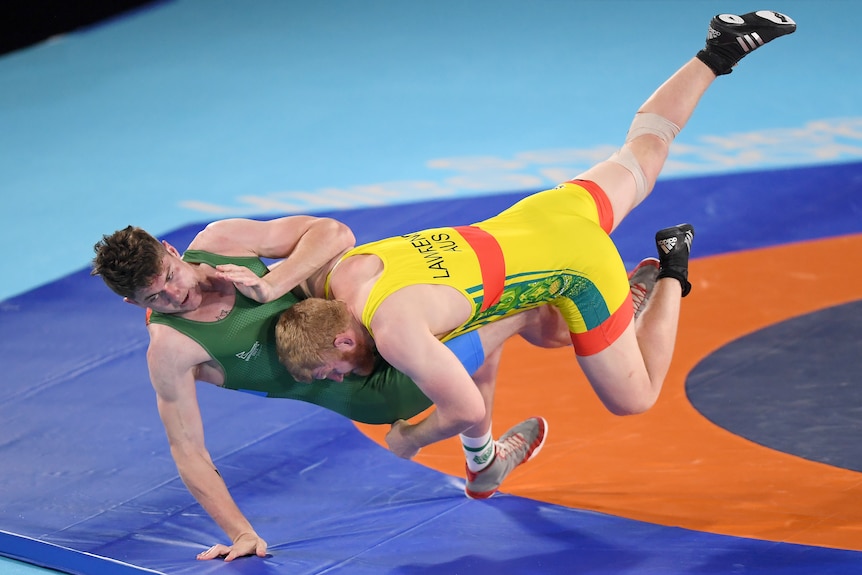 Two men wearing leotards wrestling at an event