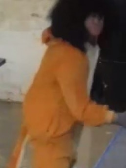 Image taken from security camera video of a person in a yellow lion costume.