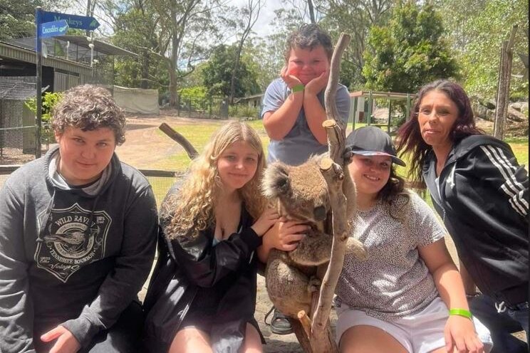 A family pose with a koala 
