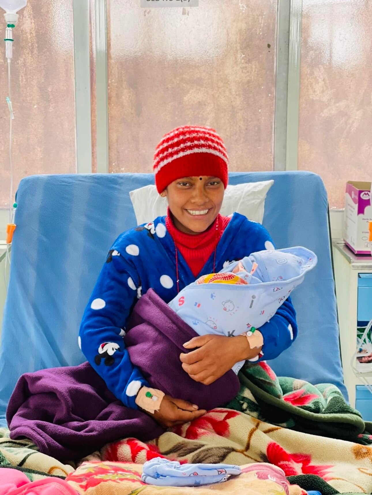 Nepalese woman holds baby at Dolakha hospital