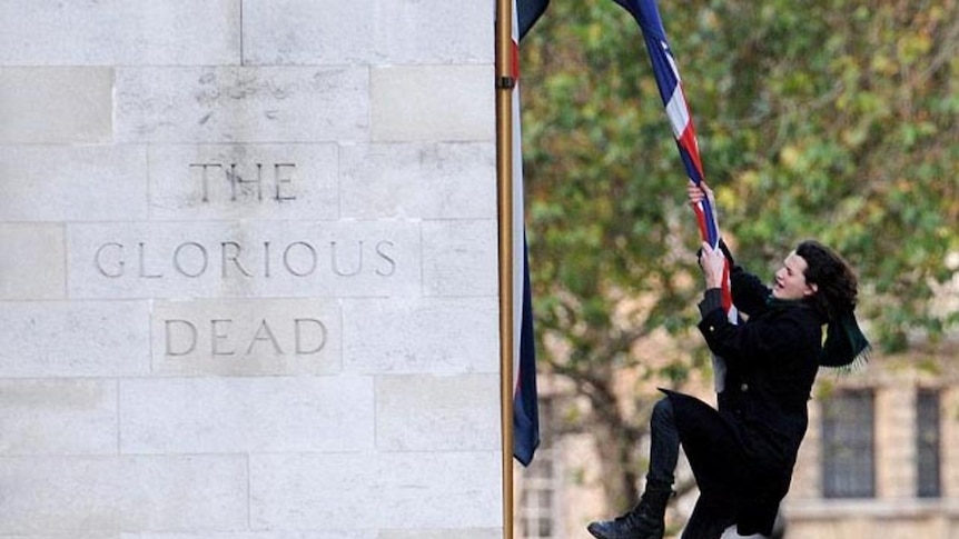 Charlie Gilmour swings from the national union flag