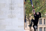 Charlie Gilmour swings from the national union flag