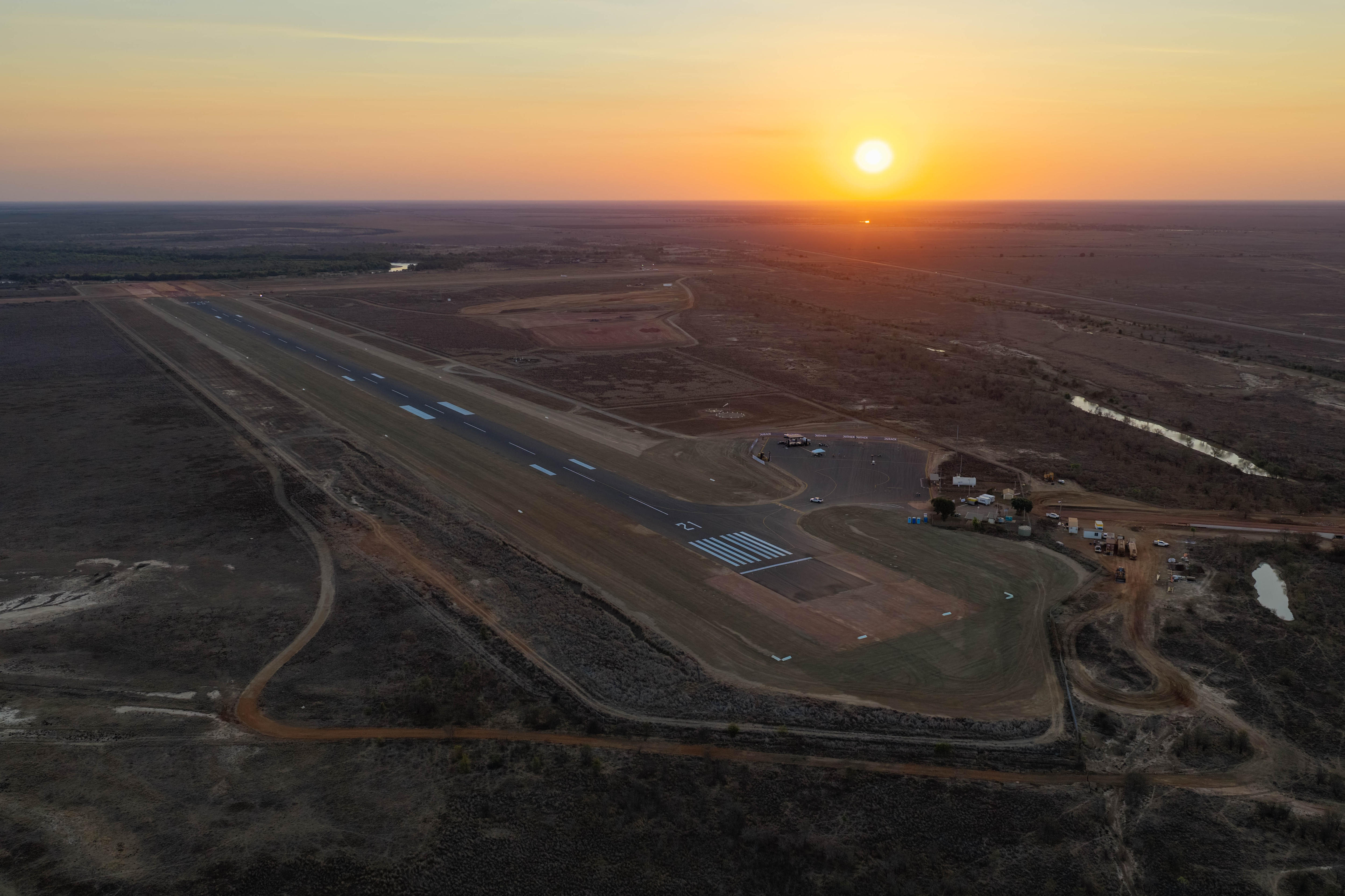a drone shot of the burketown airstrip with a sunset over the horizon in the background