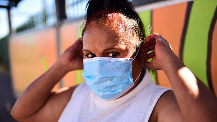 Chantelle Baker, recently released on Bail, wears a medical mask.
