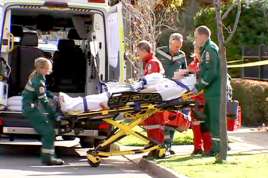 Paramedics surround a stretcher carrying a shooting victim.