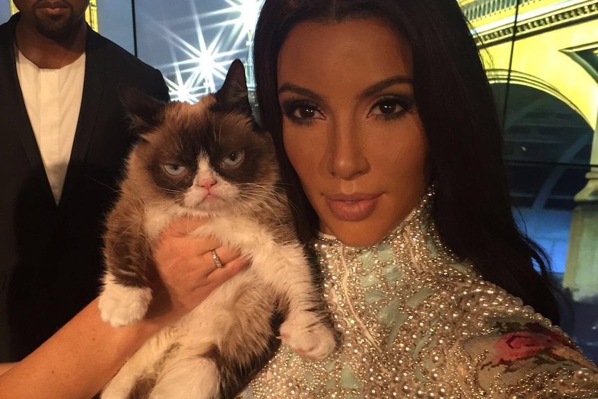 Grumpy Cat poses with the wax figure of Kim Kardashian at Madame Tussauds in London.