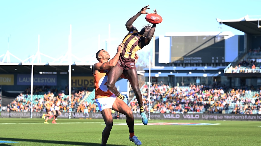 Changkuoth Jiath leaps for the ball over Callum Brown
