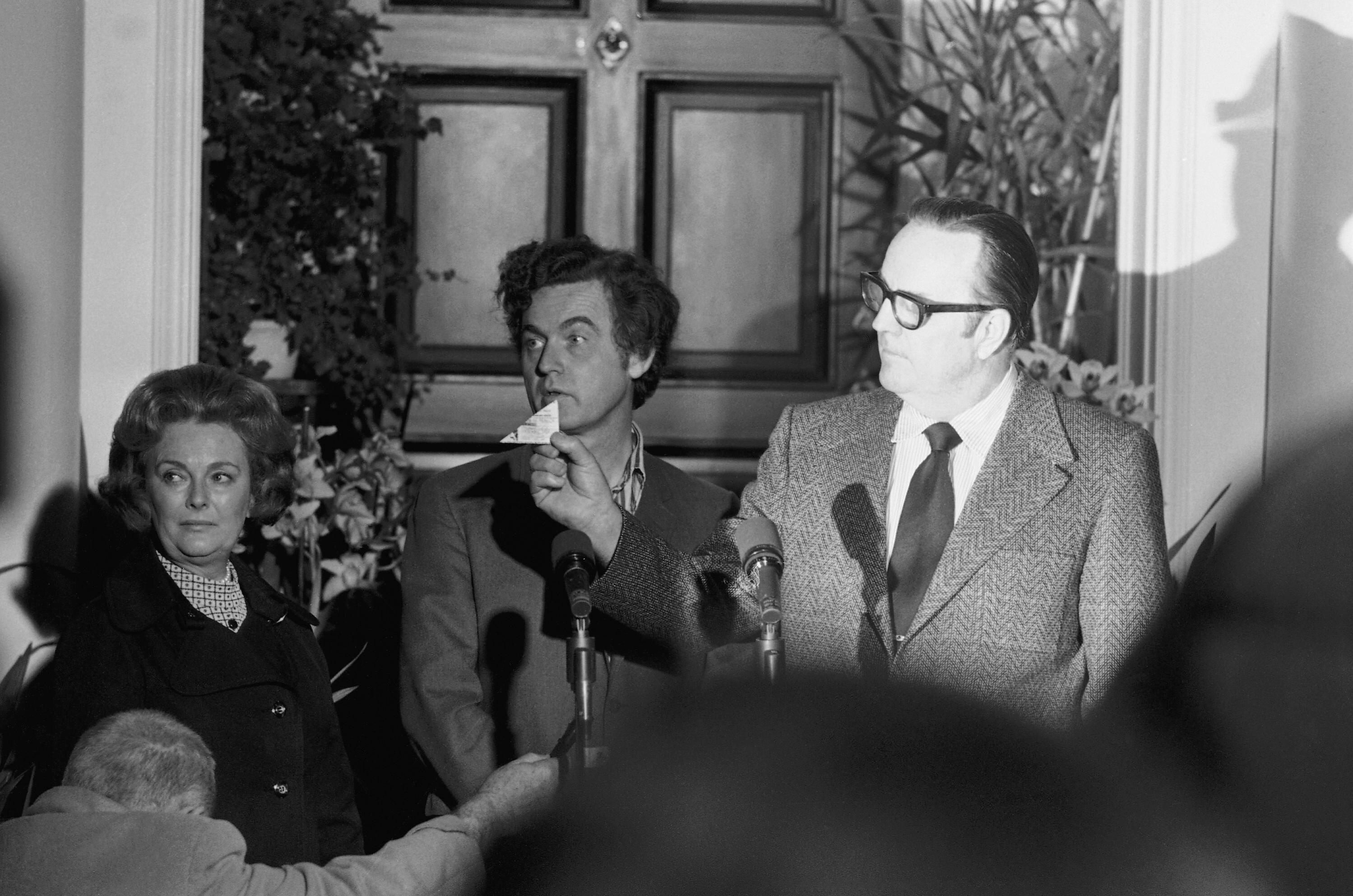 A man holds up a small piece of paper 