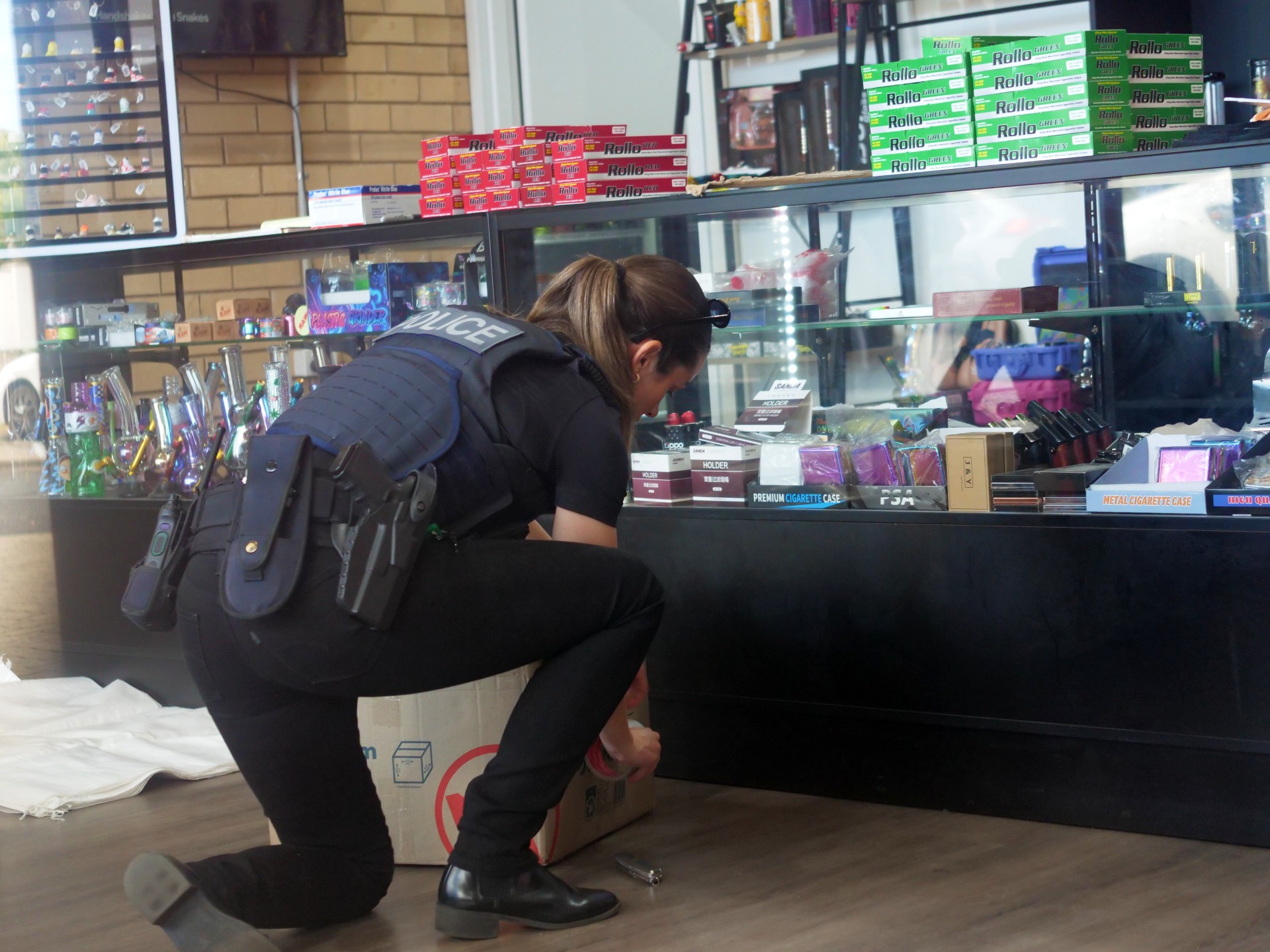 Un policía se arrodilla durante un allanamiento en una tienda.