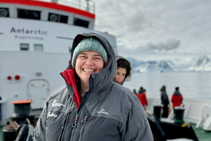 Dr Tamantha Stutchbury stands onboard the vessel as it arrives at Antarctica.