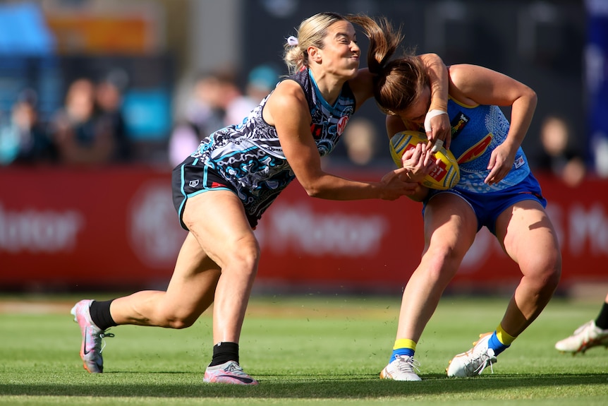 Amelie Borg Port Adelaide tackles Jamie Stanton of the Gold Coast, who ducks underneath her arm