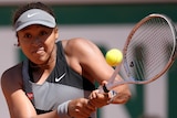 A Japanese tennis player hits a double-fisted backhand at the French Open.