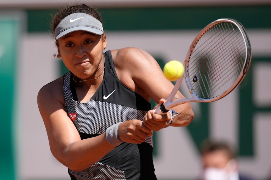 A Japanese tennis player hits a double-fisted backhand at the French Open.