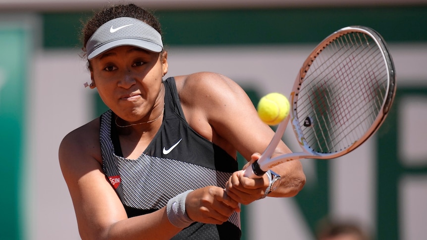 A Japanese tennis player hits a double-fisted backhand at the French Open.