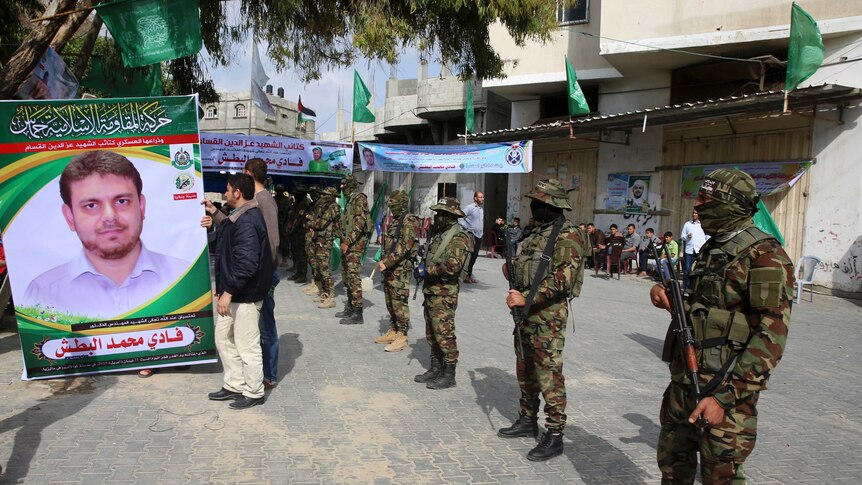 Hamas soldiers stand guard outside mourning tent for Fadi al-Batsh