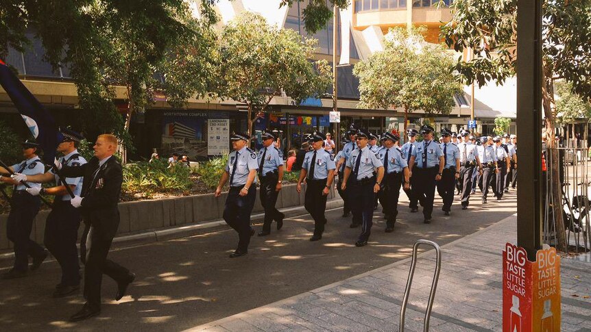 Police in Townsville in north Queensland march down Flinders Street on their way to a service for Police Remembrance Day
