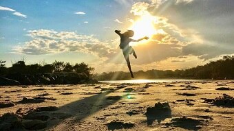 boy jumping on the beach during sunset