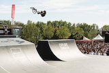 Professional freestyle BMX rider Logan Martin int he air in skate bowl event in New Zealand.