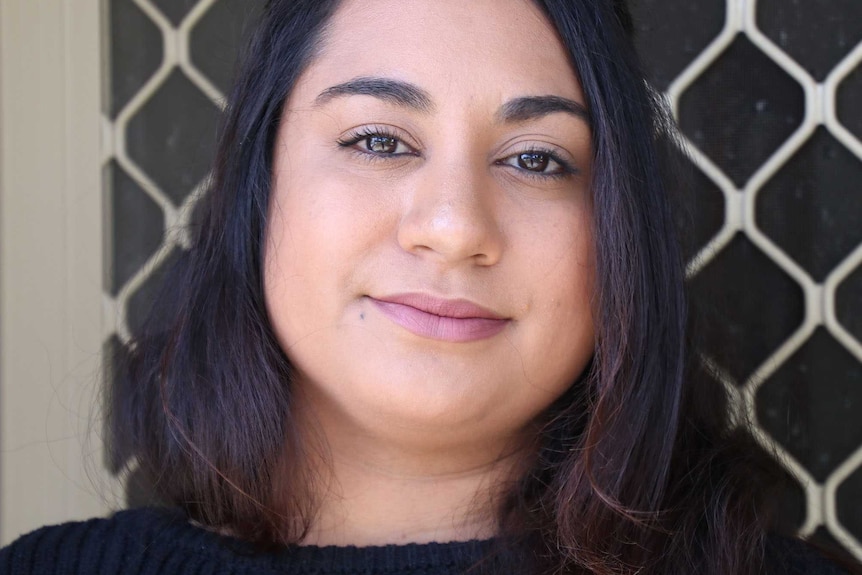 A headshot of a woman outside her front door.