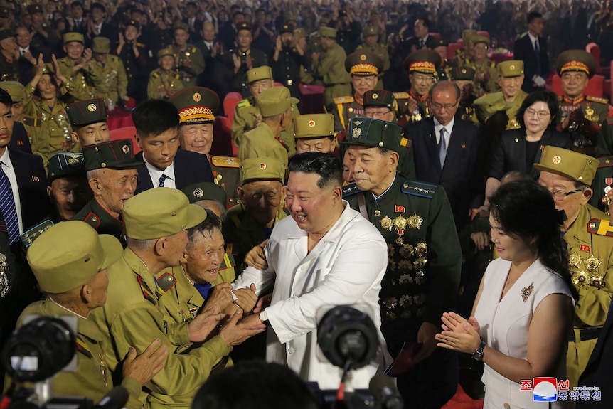 North Korean leader Kim Jong Un shakes hands with war veterans