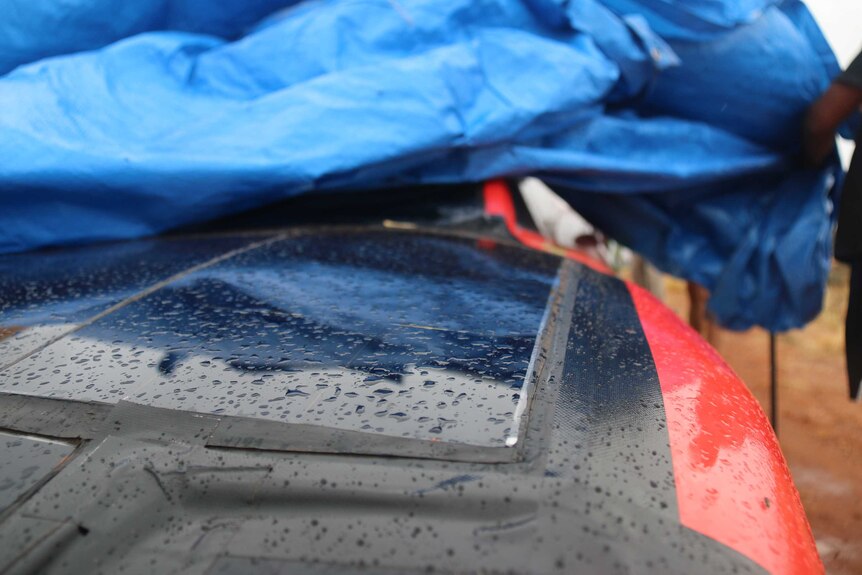 A close up shot of the a car's solar panels covered with rain droplets.