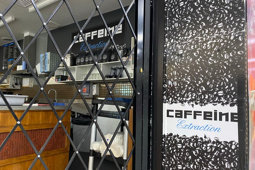 A cafe with a closed black gate.