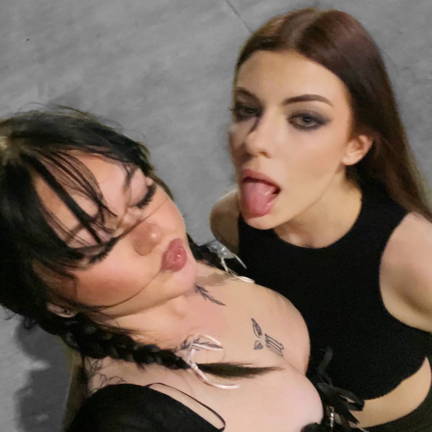 Caitlin and Willow, both wearing black, take a selfie.