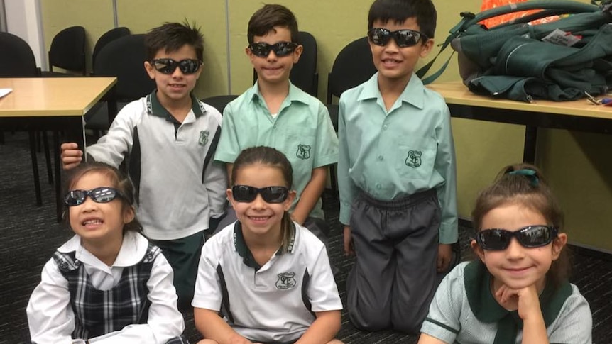 Students pose with sunglasses in the classroom