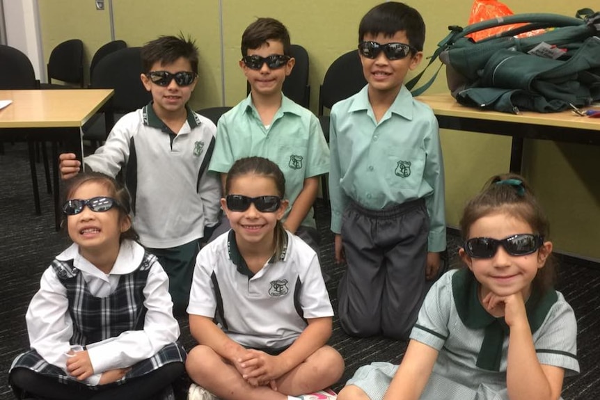 Students pose with sunglasses in the classroom