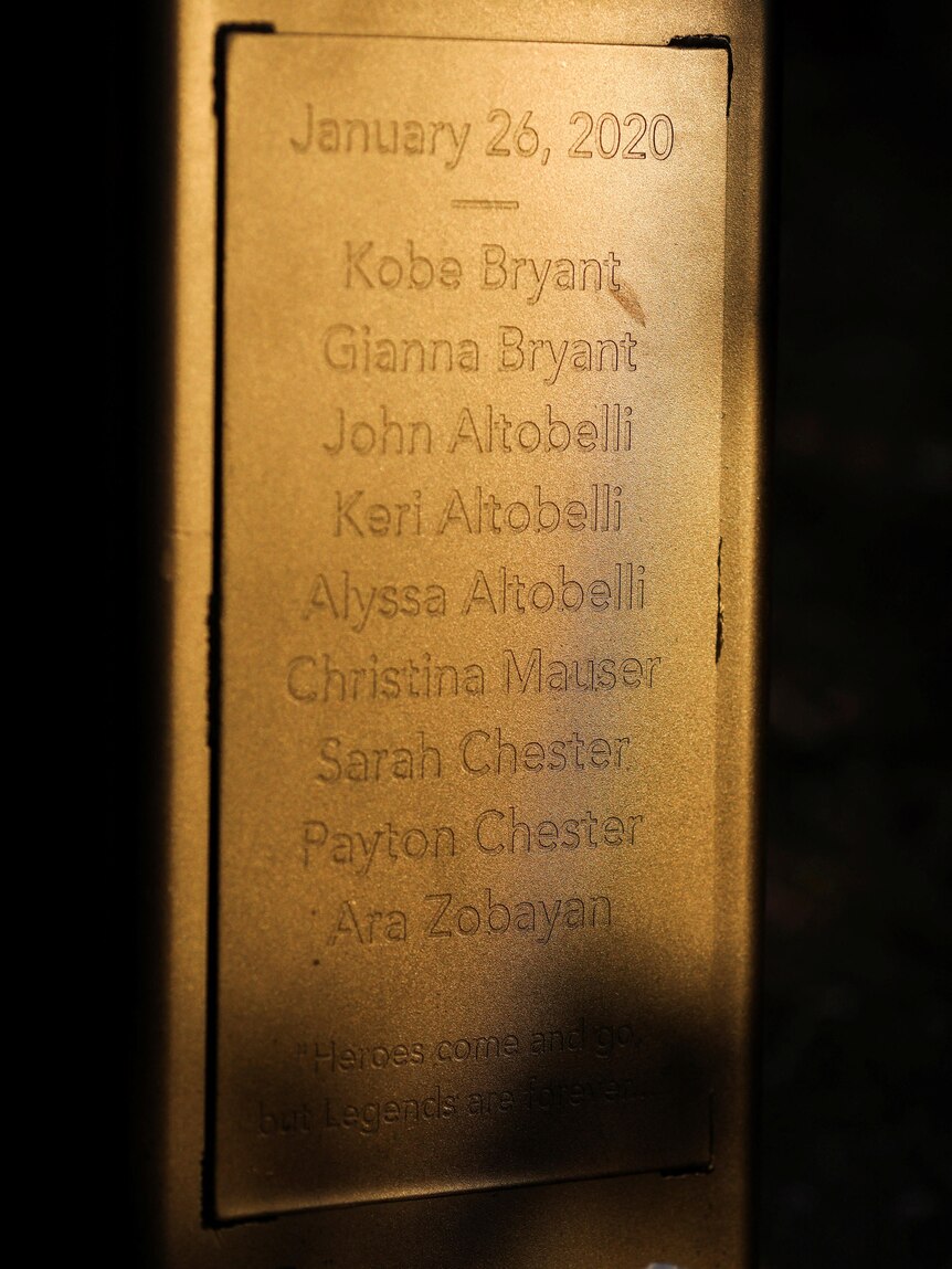 Nine names engraved on the base of a bronze statue.