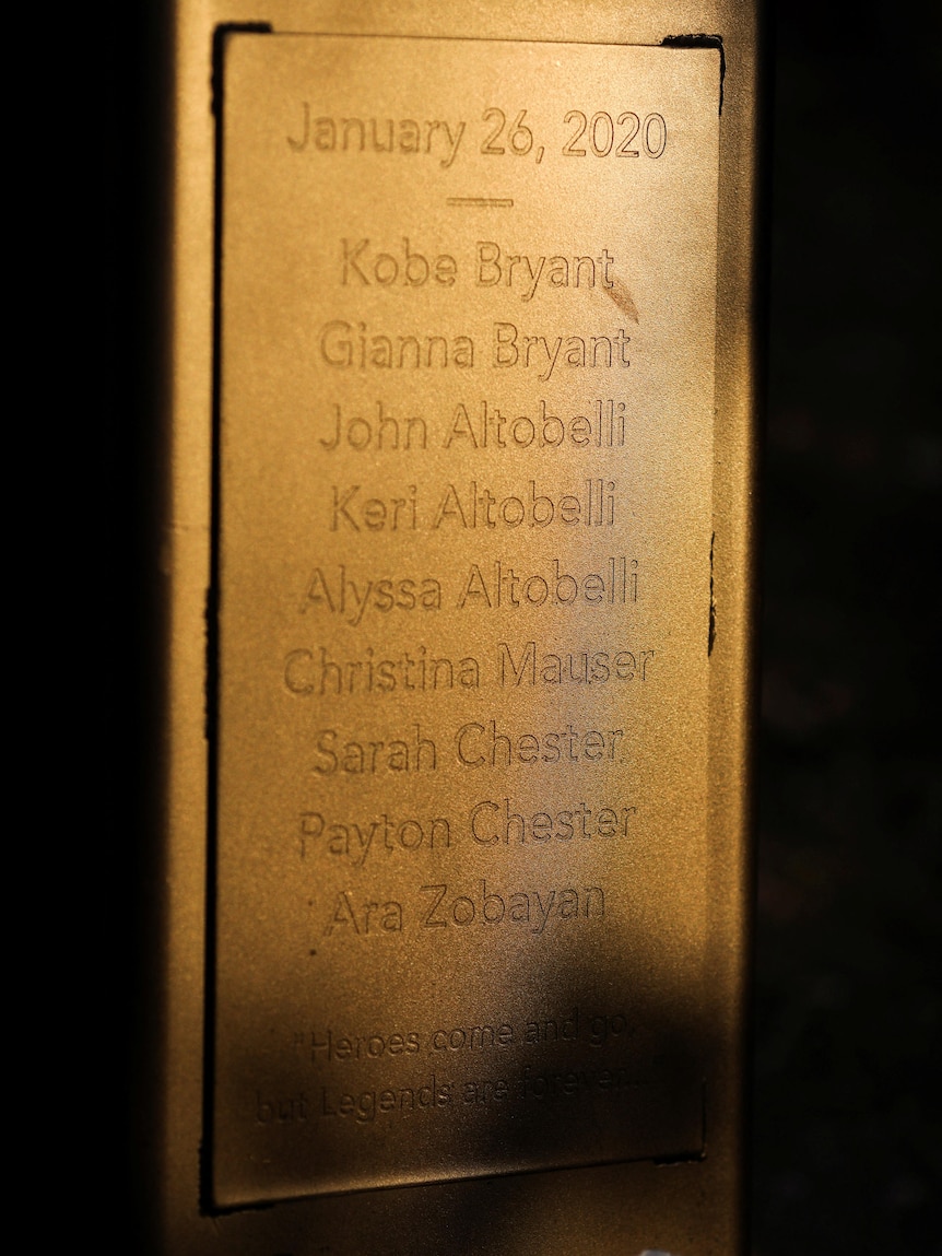 Nine names engraved on the base of a bronze statue.