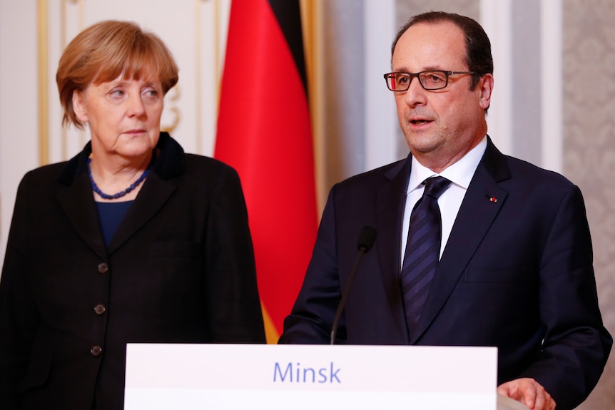 德国总理默克尔（左）和法国总统弗朗索瓦-奥朗德一同站在讲台上。
