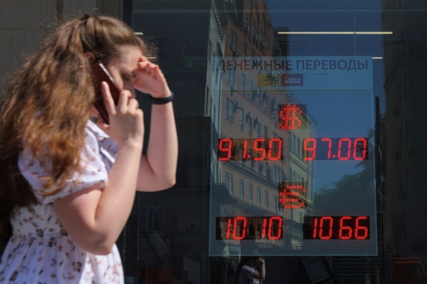 A board shows currency exchange rates in a street in Moscow.