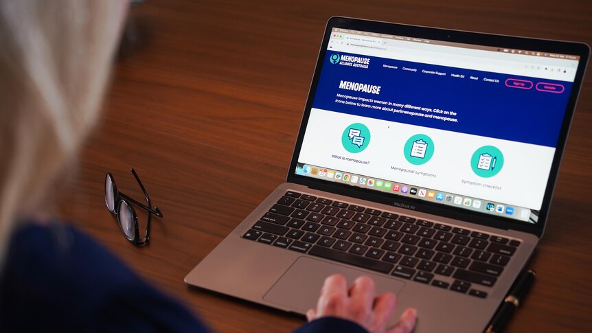 The Menopause Alliance Australia website appears on a laptop screen as a woman sits out of shot with her hand on the keyboard.