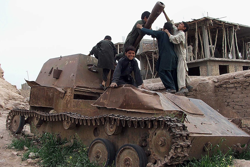 Afghan children play on a Russian tank.