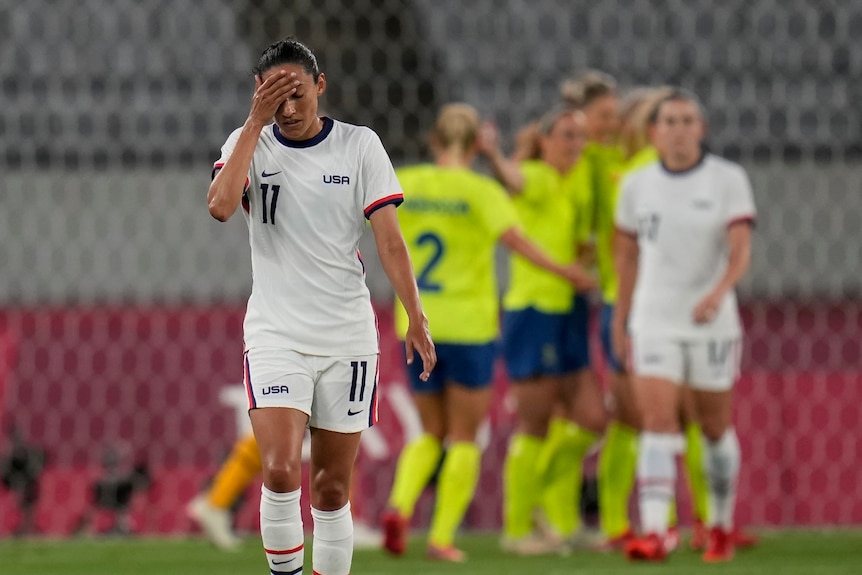 美国女子足球运动员克里斯汀·普雷斯在离开庆祝瑞典人时用手抚摸她的前额。