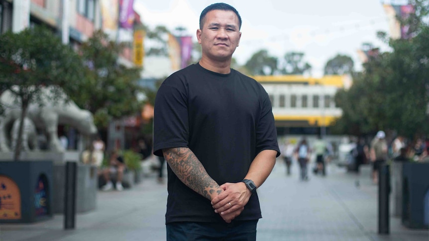 Tony Hoang wearing a black T shirt standing in Cabramatta