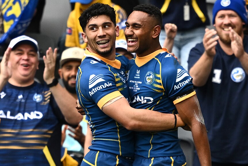 Two Parramatta Eels NRL players embrace as they celebrate a try.