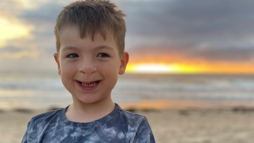Boy with a cleft palate in front of a sunset