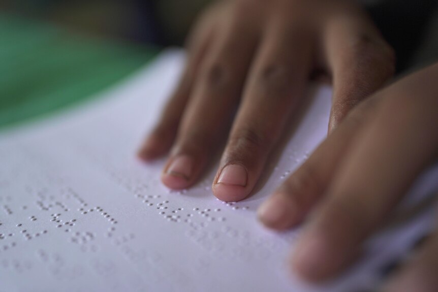 Close up of braille, a teenage boy's hands touch